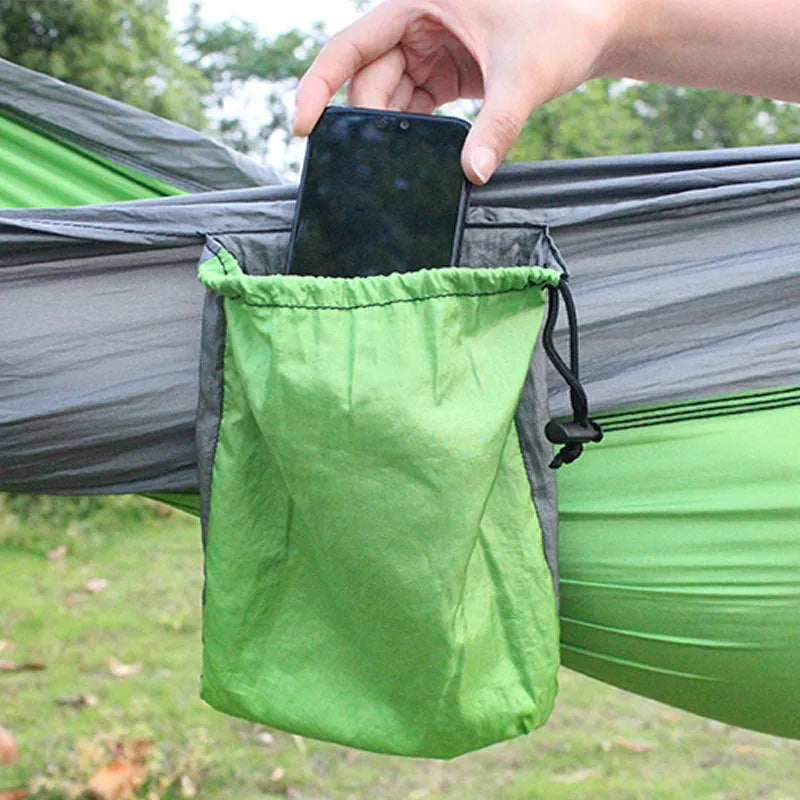 Blue ripstop nylon outdoor hammock with suspension ropes hung between trees