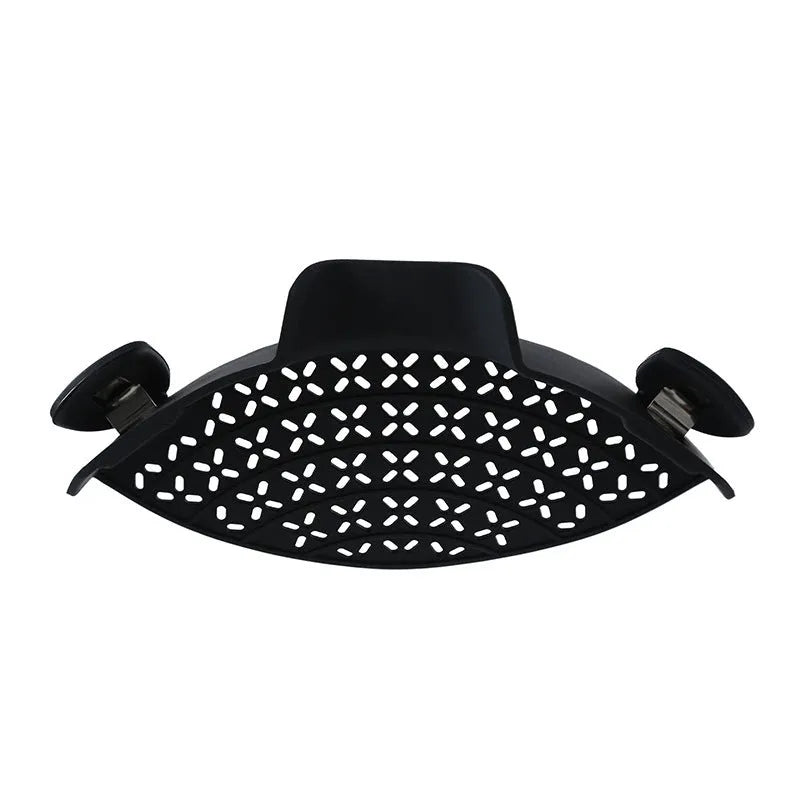 Silicone pot side drain stopper in black attached to saucepan rim with leak-proof edge