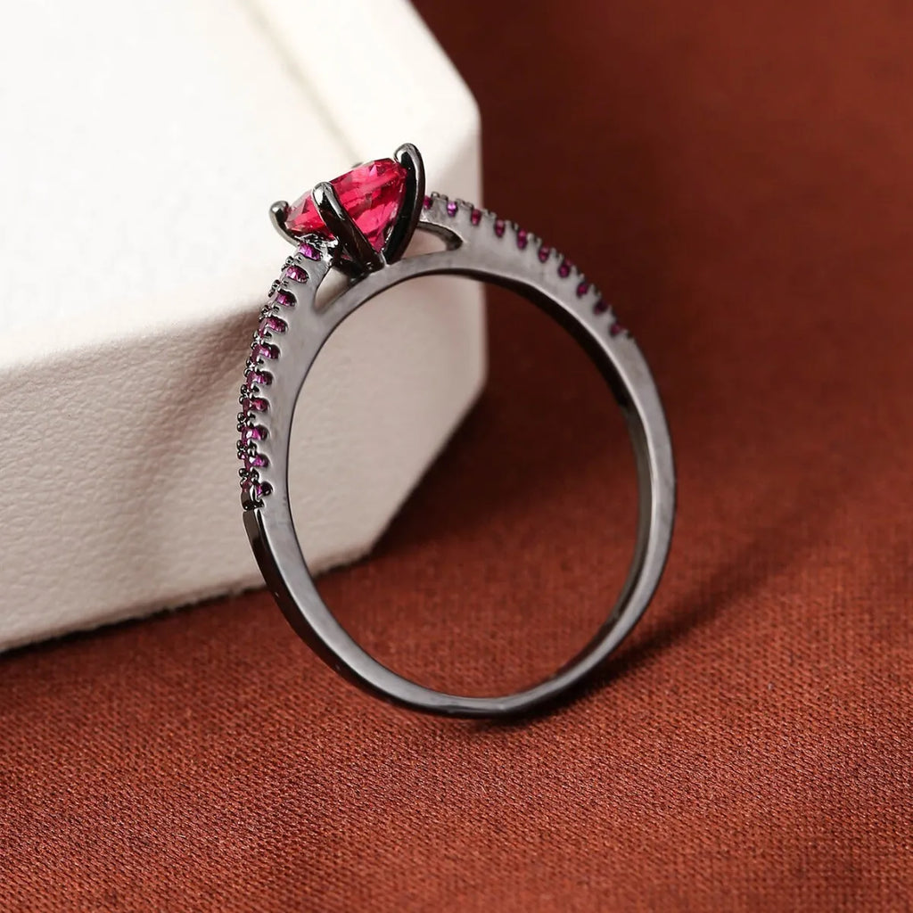 Hexagonal geometric copper ring with zircon electroplating in a gold rose red finish on a hand.
