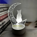3D LED light moon and cat shape acrylic panel with remote control and USB cable on a dark surface