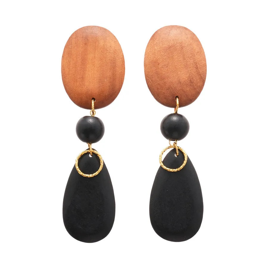 Handmade brown and black wooden ellipse earrings with silver needle fastenings on a white background.