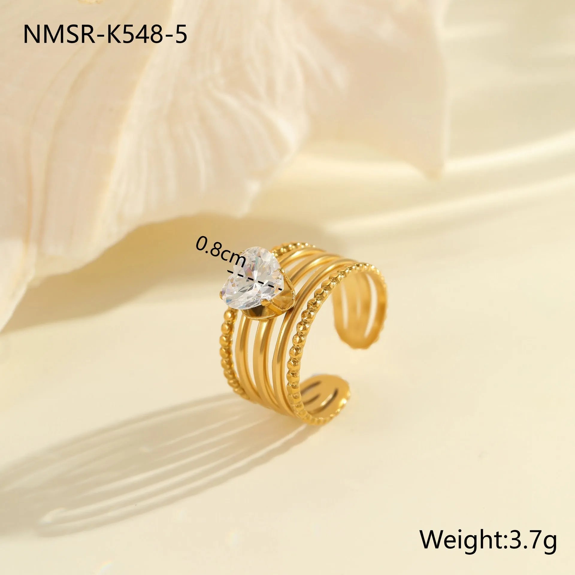 Gold-coloured adjustable stainless steel ring with zircon geometric shapes on white background.