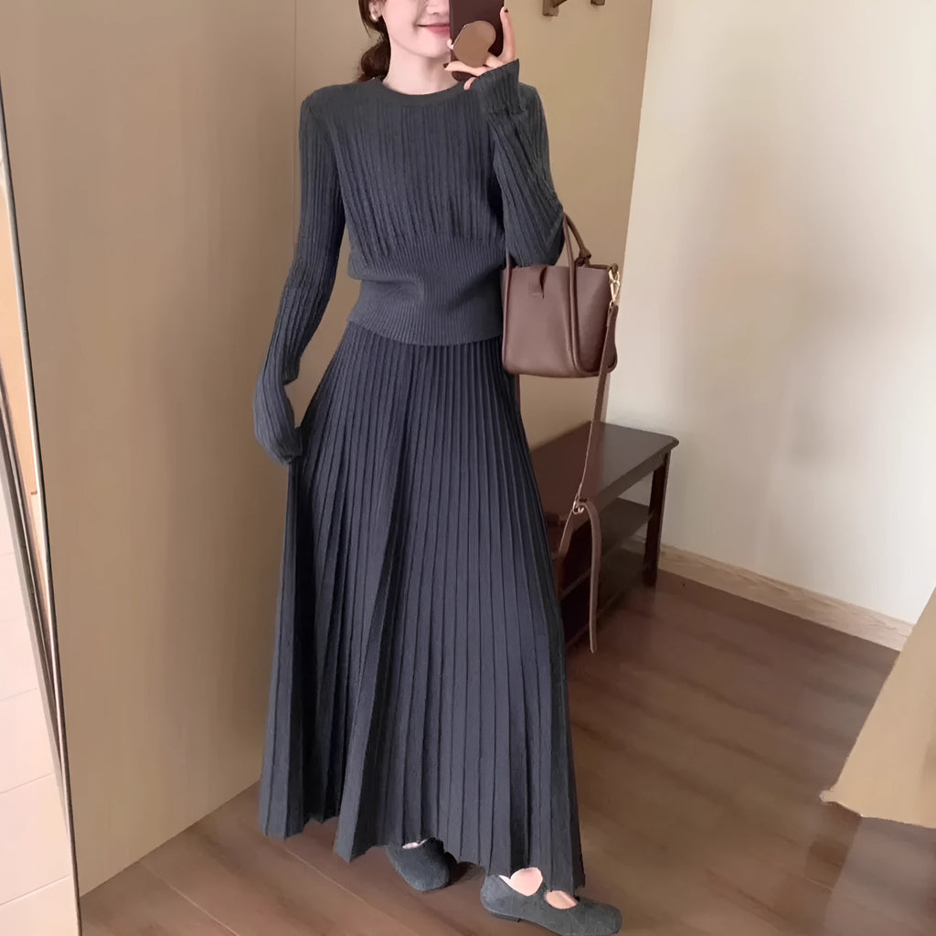 Women's dark grey knitted sweater and skirt suit set with textured 3D pattern and collage stitching.