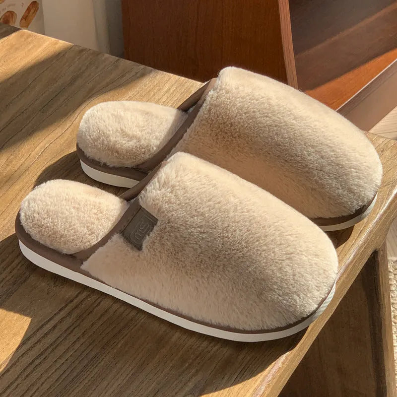 Solid colour PVC plush winter house slippers on a wooden floor.
