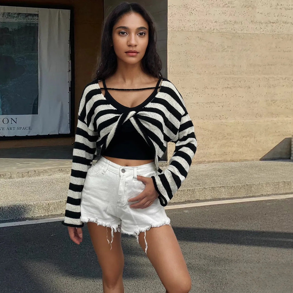 Woman wearing a striped long-sleeved cropped sweater in mercerised cotton, showcasing front and back wearable design.