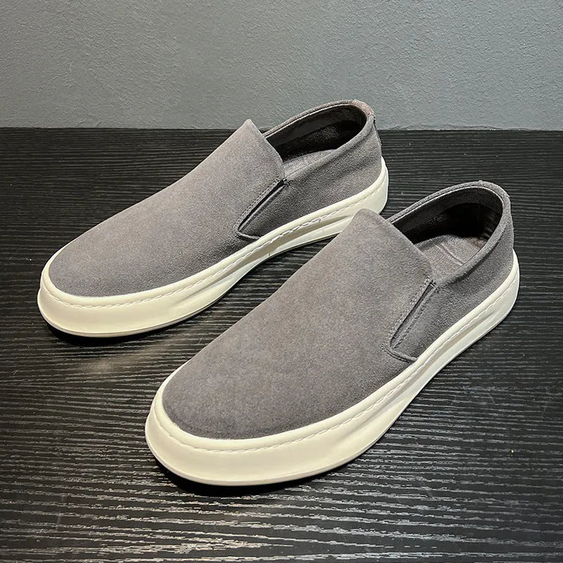 Men's grey slip-on casual shoes with round toe design and visible stitching details