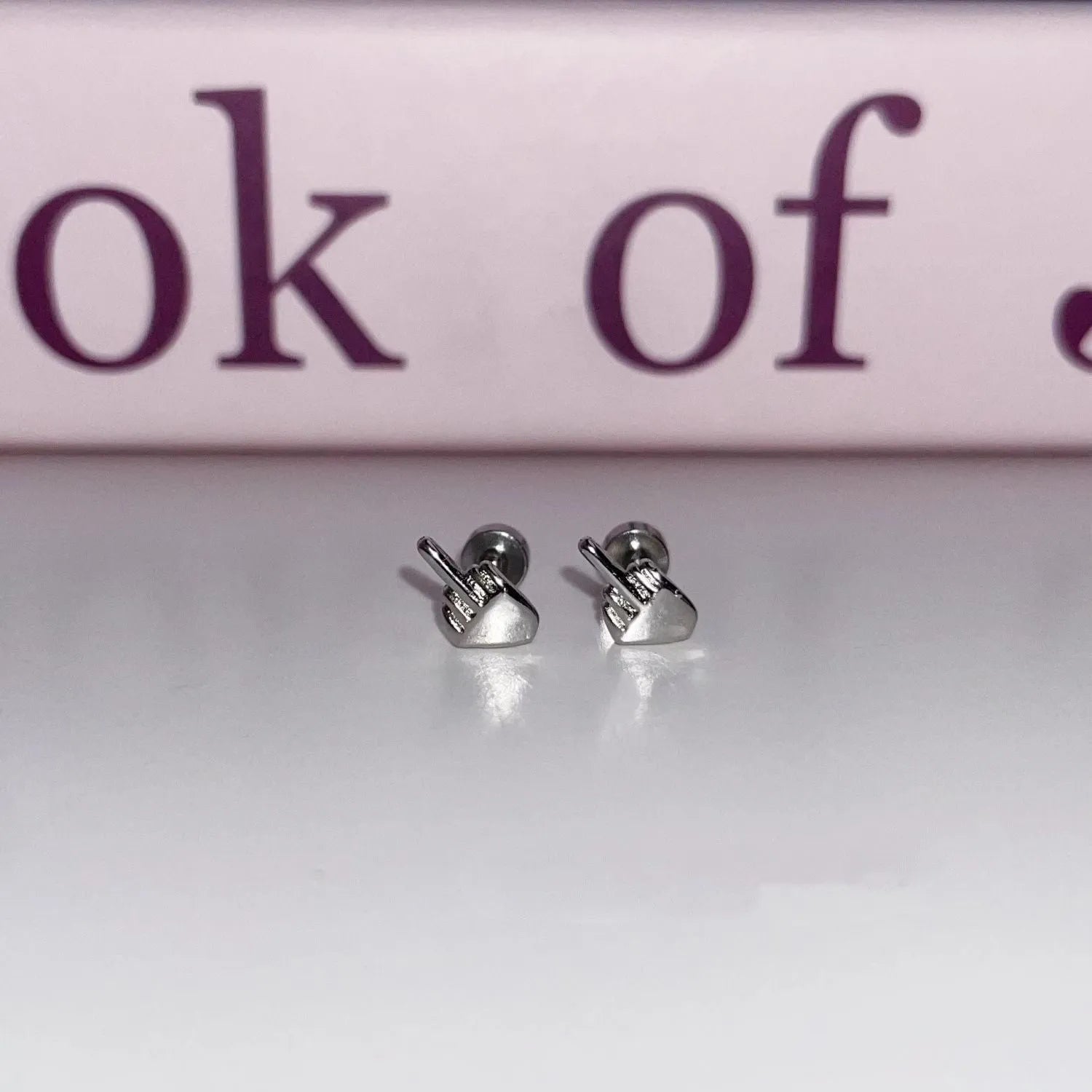 Niche quirky middle finger alloy screw clasp ear cartilage earring for women, vertical motif, bow shape, one pair