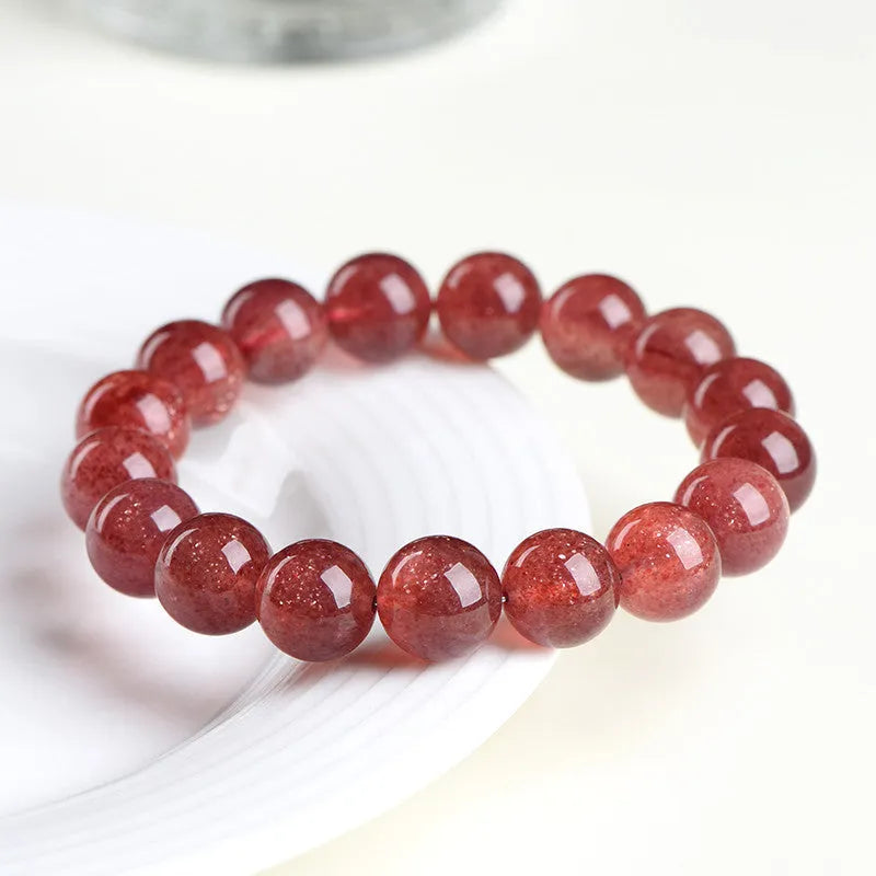 Natural red strawberry quartz crystal bracelet with geometric cut beads, shown in unisex styling.
