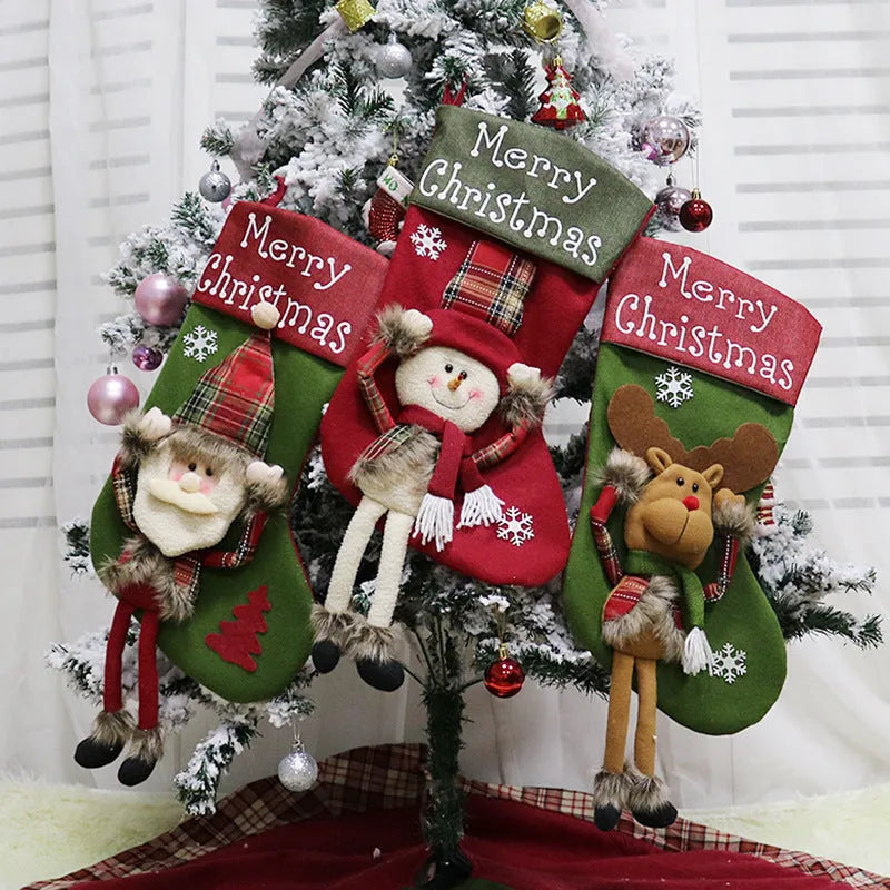 Set of three large 18-inch Christmas stockings with Santa, Snowman, and Reindeer 3D applique designs, hanging on a wooden mantel with festive decorations.