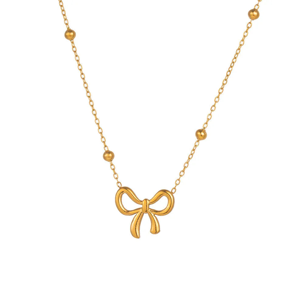 Gold bow necklace with titanium steel cross chain on white background