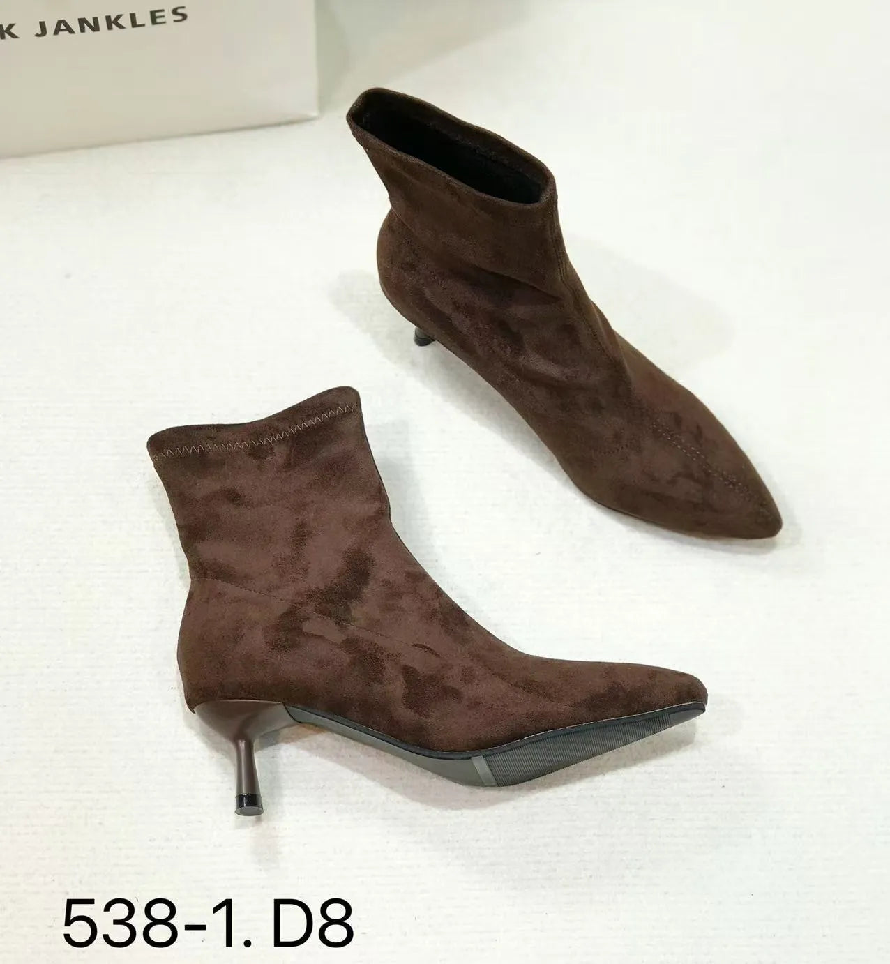Black pointed toe women's ankle boots with stiletto heels on a neutral background.