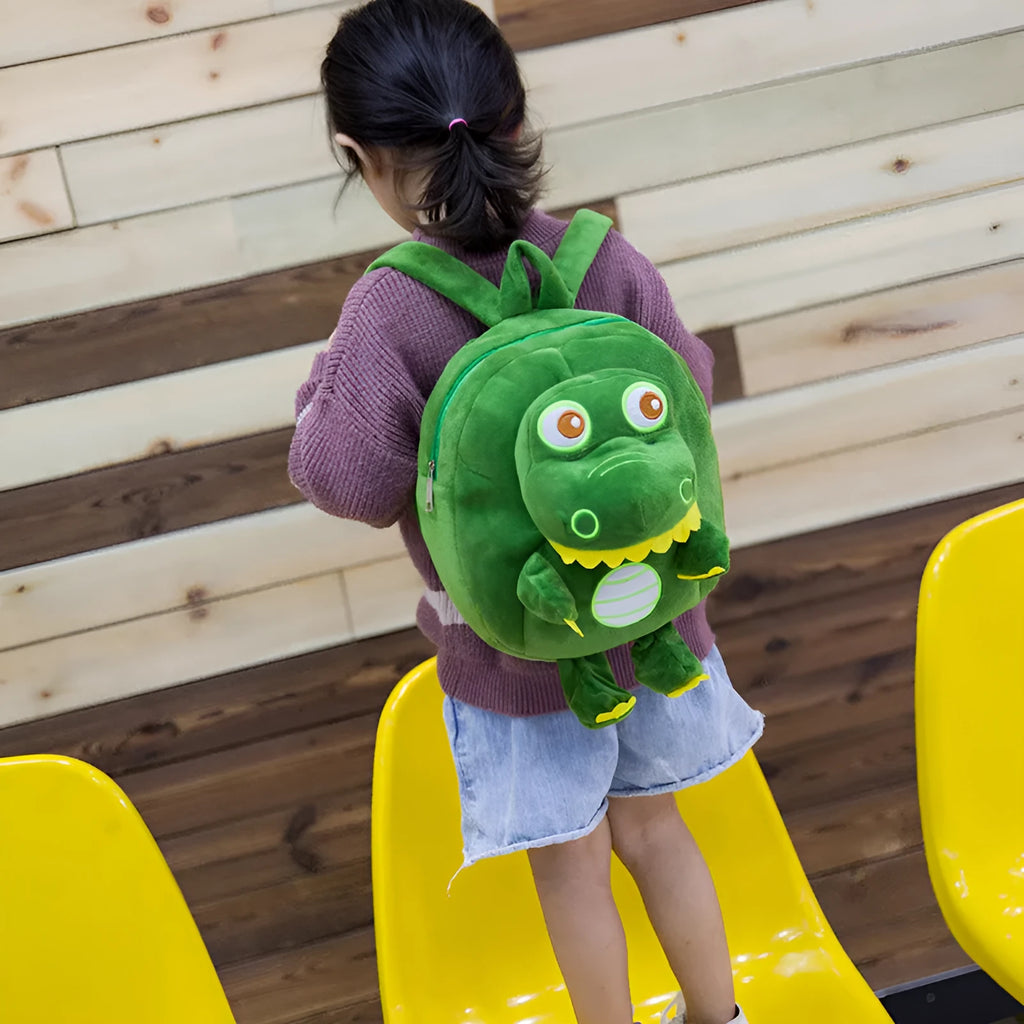 Soft blue plush dinosaur backpack for children with embroidery details and a single handle.