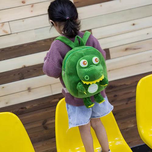 Soft blue plush dinosaur backpack for children with embroidery details and a single handle.