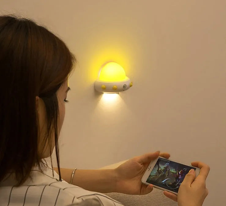 Remote control UFO shaped bedside night light in blue, pink, or white with cartoon design