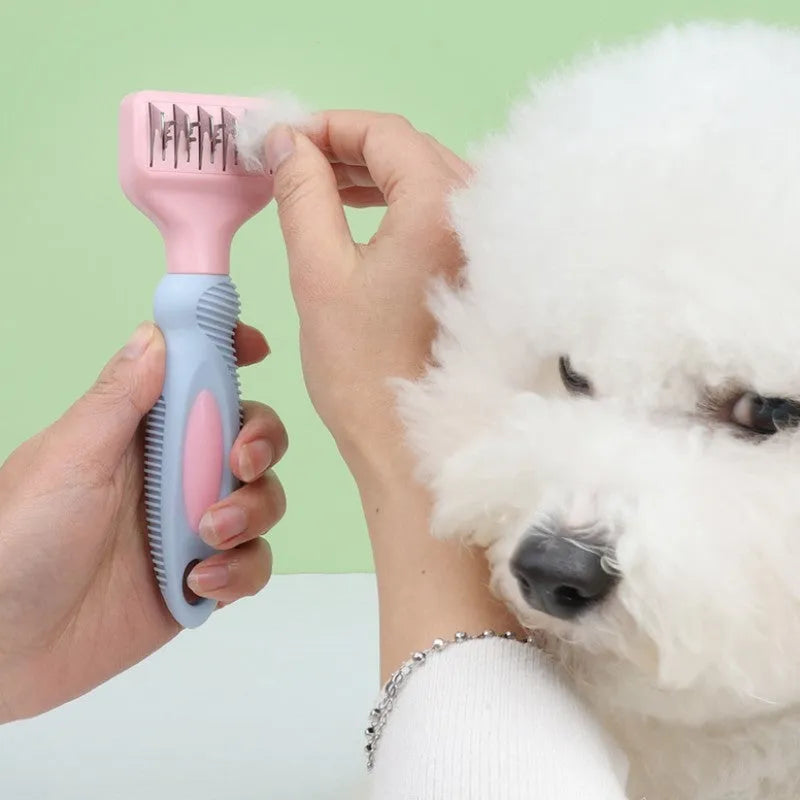 Pink stainless steel dog grooming comb with knot knife and massage pins on a white background.