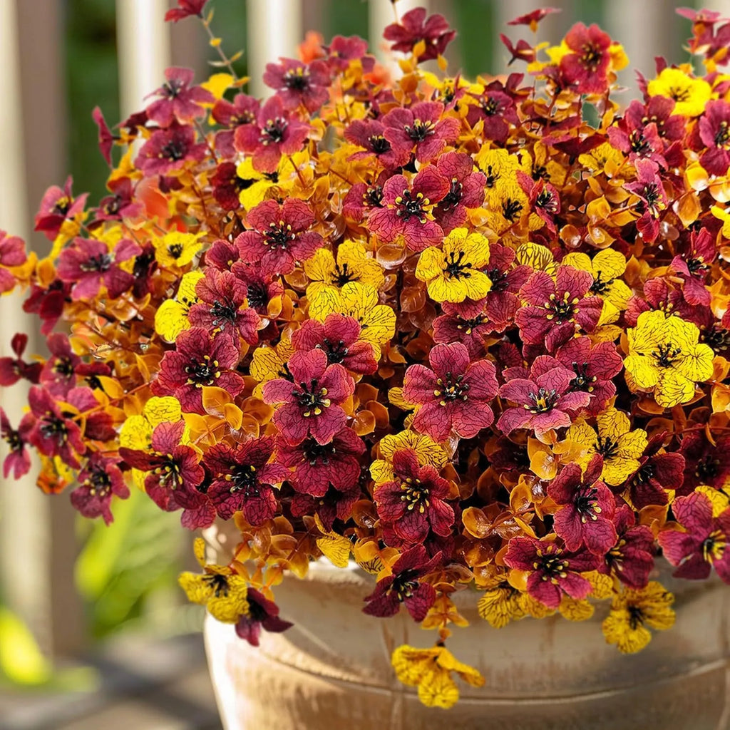 Artificial flower bouquet in autumn red, yellow, orange and orange-yellow colours for home and wedding decoration