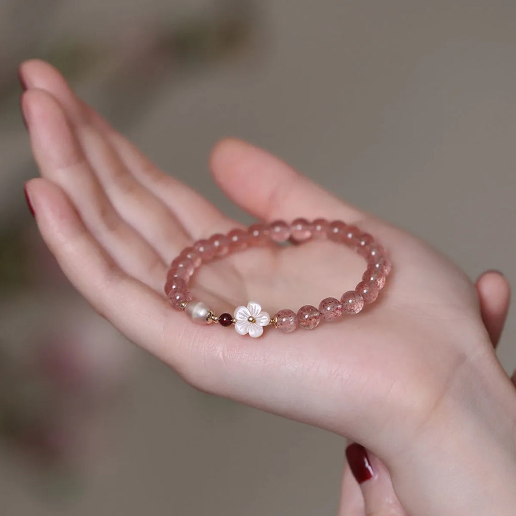 Strawberry quartz peach blossom bracelet with crystal flower charm and gemstone beads.