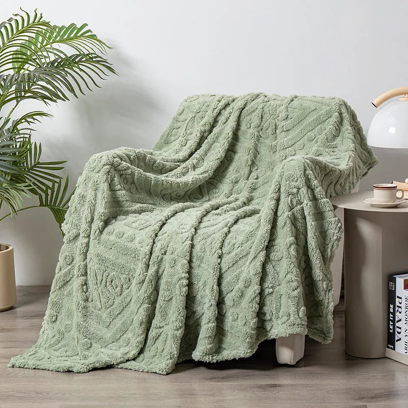 Shu Cotton Velvet Jacquard blanket in fog blue with a woven plant flower pattern, laid flat.