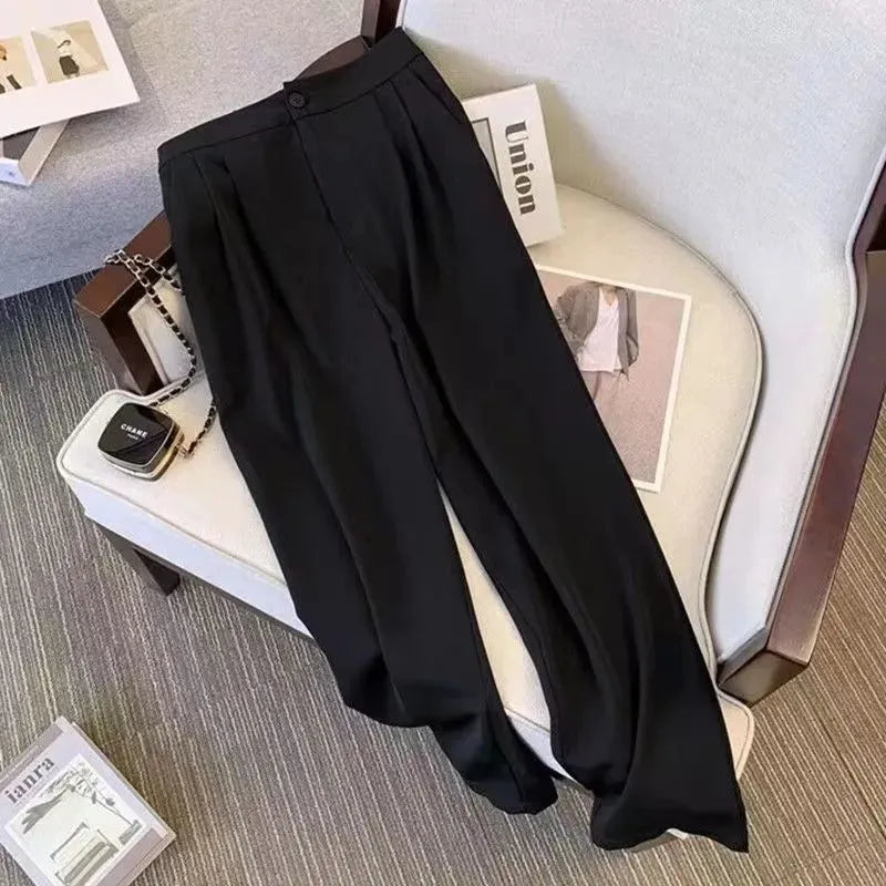 Women's loose black polyester blouse with regular sleeves on a hanger.