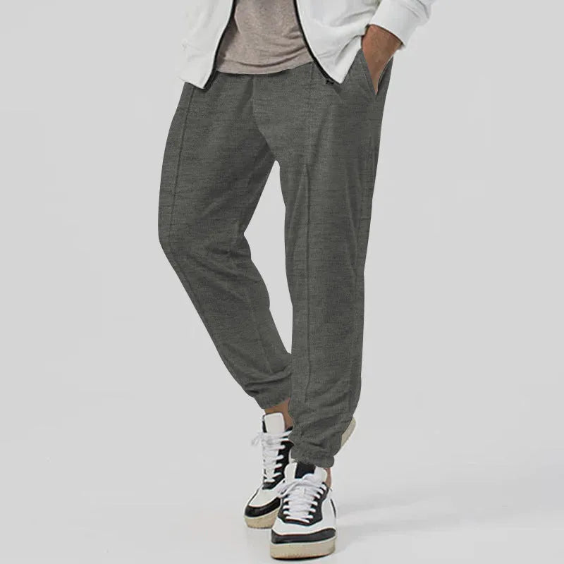 Men's loose tapered casual track sweatpants in cotton blend fabric showing straight-leg design