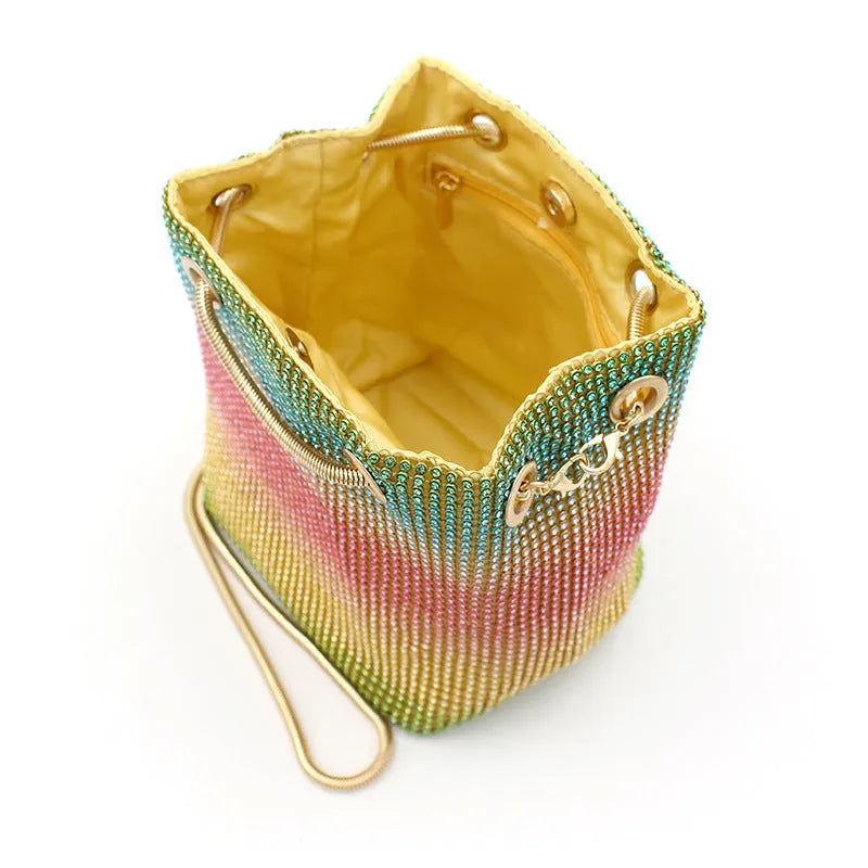 Colourful rainbow design rhinestone bucket bag with a soft fabric texture and a handle.