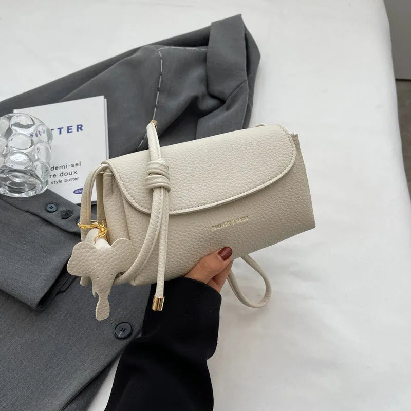 Soft PU small shoulder bag in khaki with pillow silhouette and sewing thread detail, 21cm wide.
