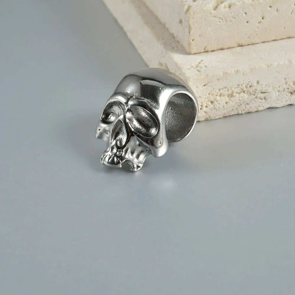 Stainless steel hollow skull Buddha earrings showing four colour finishes on geometry design