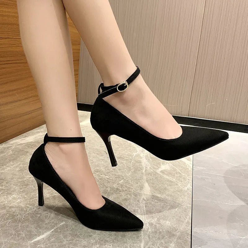 Women's black stiletto heel pump with ankle buckle detail and a rubber sole.