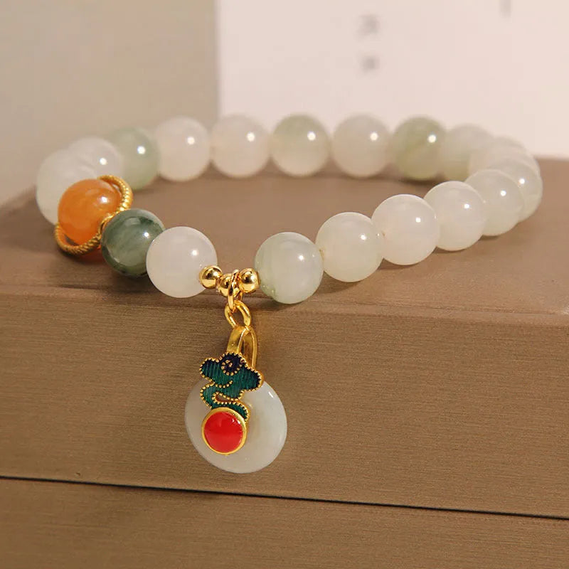 Close-up of a women's ice jade bracelet with a peace jade buckle and pearl decorative elements.