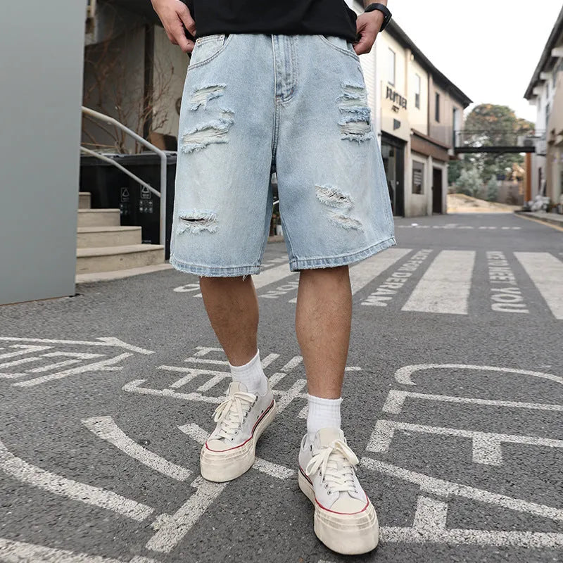 Light blue ripped denim shorts with a loose, straight-leg fit on a neutral background.