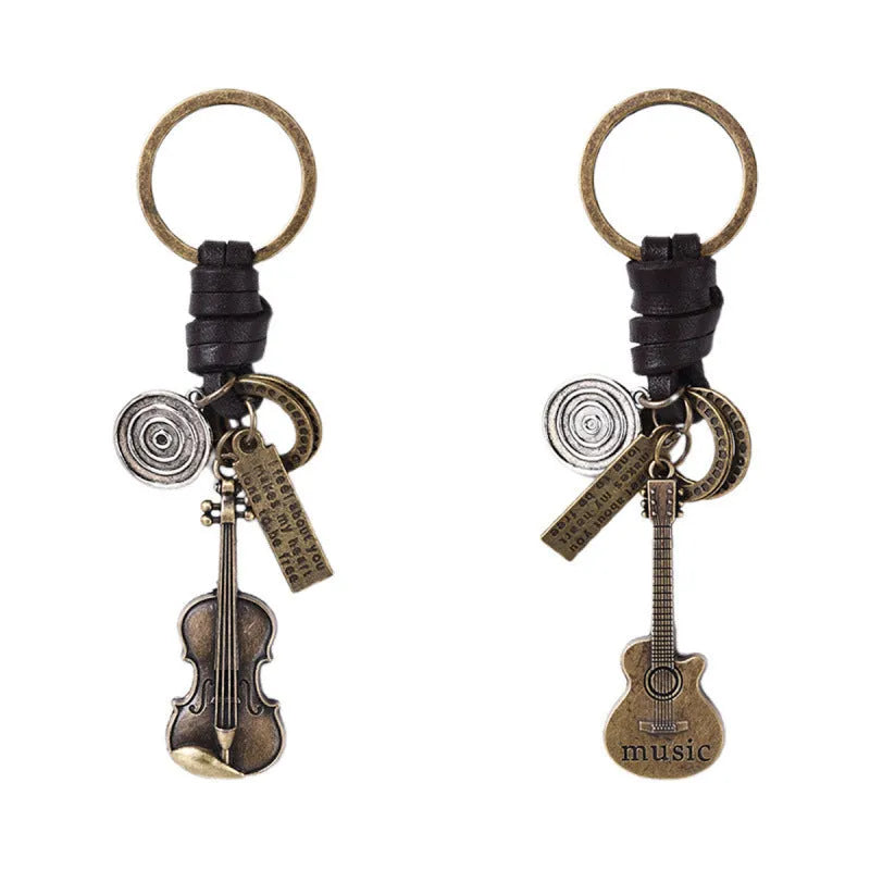 Retro guitar keychain pendant with woven cowhide charm and electroplated alloy finish on white background