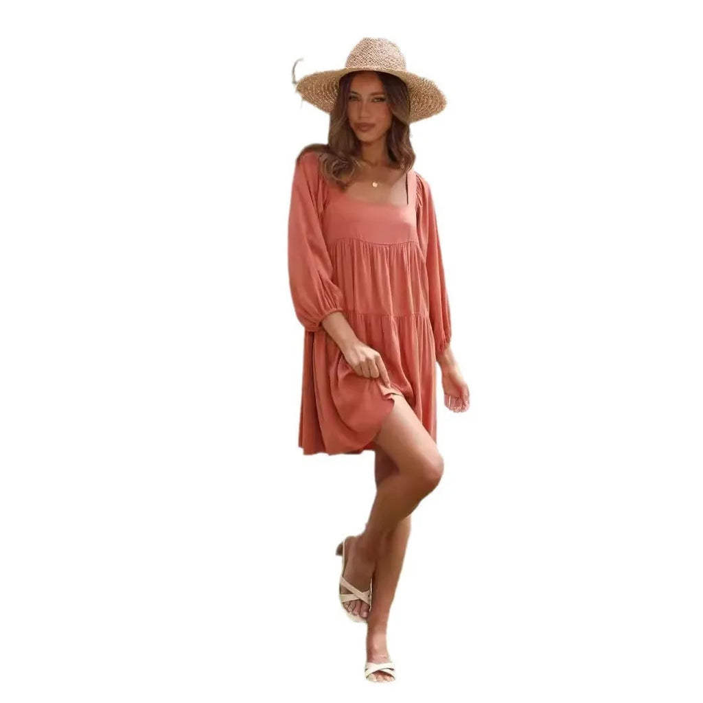 A child's orange puff sleeve dress with a square collar and backless design, featuring an A-line silhouette.