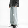 Men's light blue washed straight leg jeans with button waistband on size chart background
