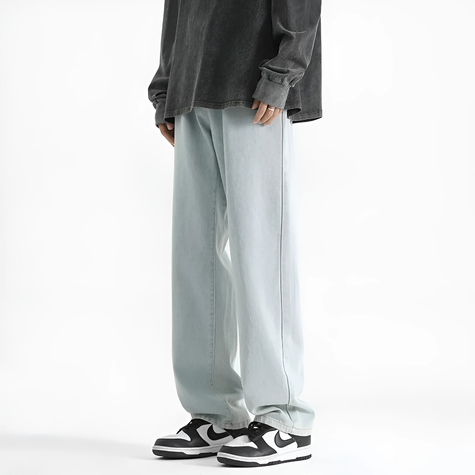 Men's light blue washed straight leg jeans with button waistband on size chart background