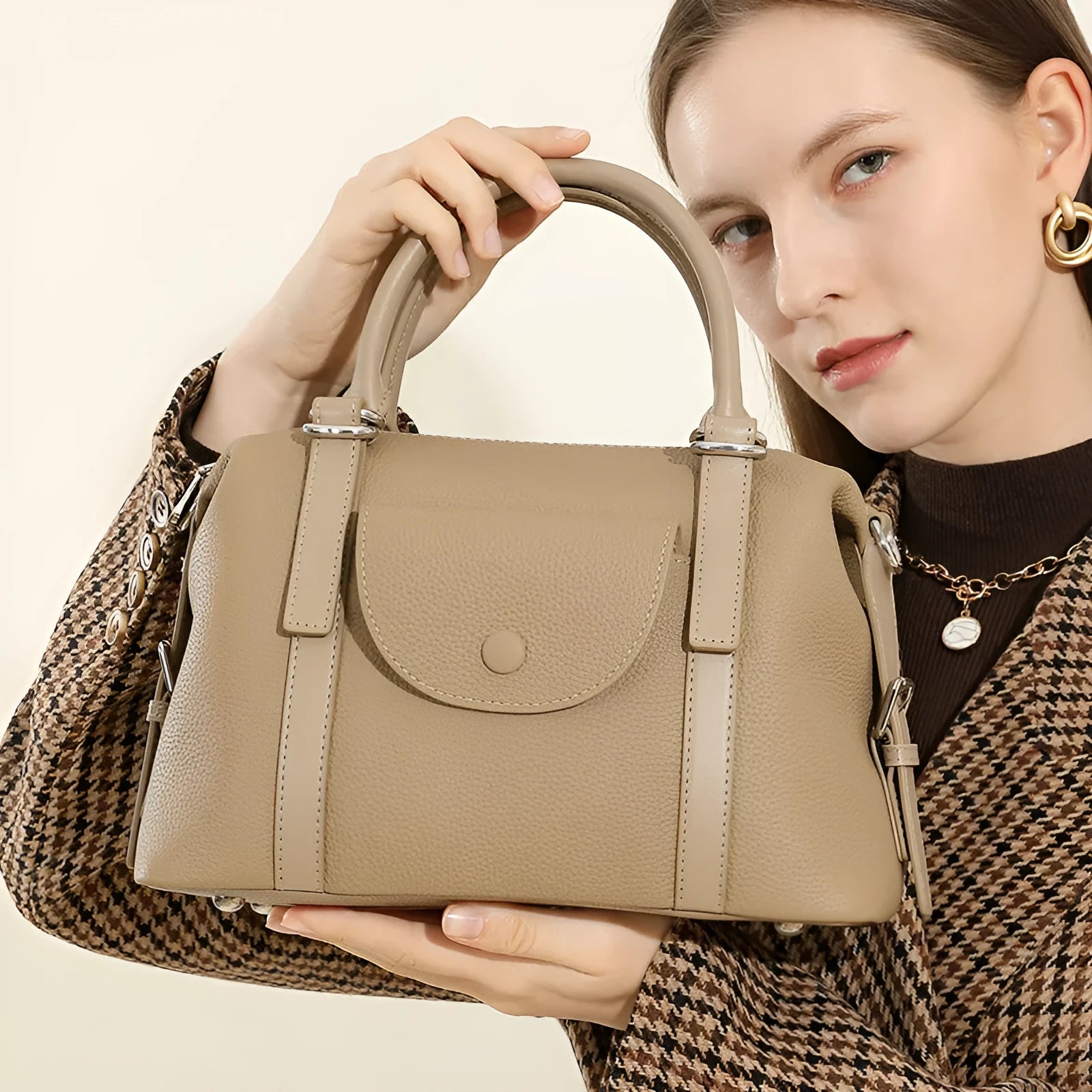 Genuine leather ladies handbag in street trend style with contrast stitching and lock detail.