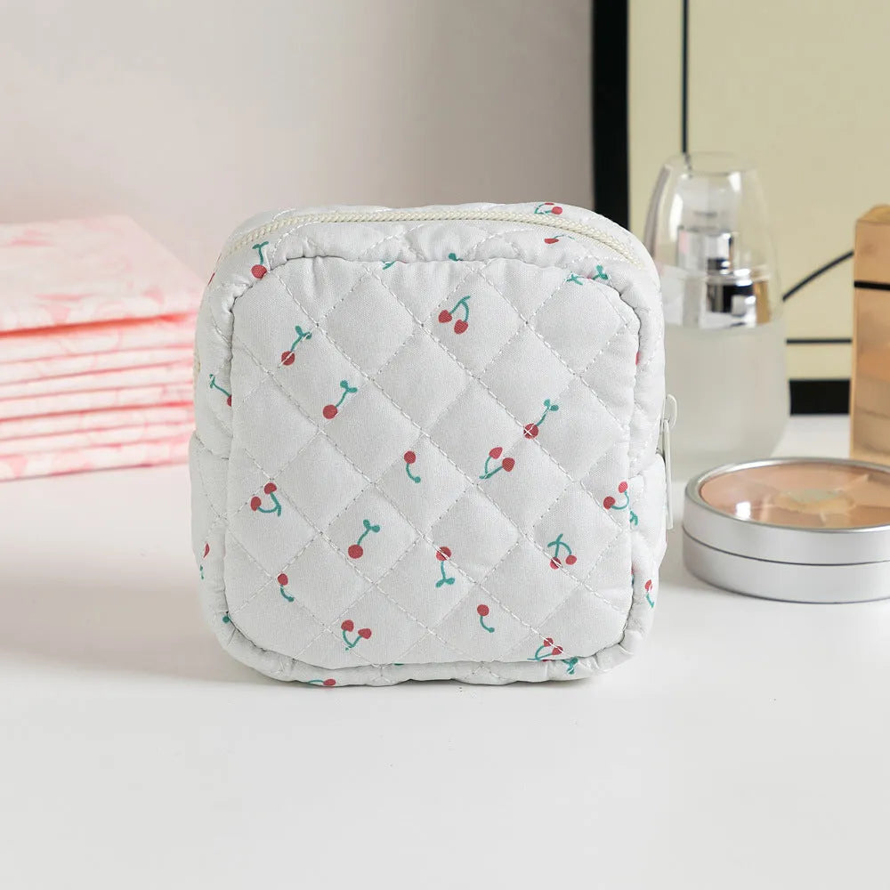 Yellow floral polyester key storage bag with sewing thread detail next to red small flower design variant.