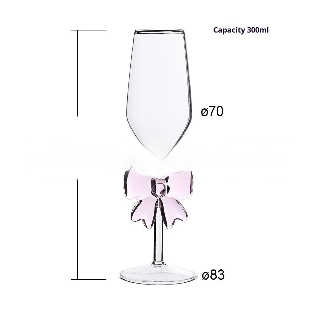 Set of three clear borosilicate glass candlesticks with large bow decorations on a table