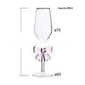 Set of three clear borosilicate glass candlesticks with large bow decorations on a table