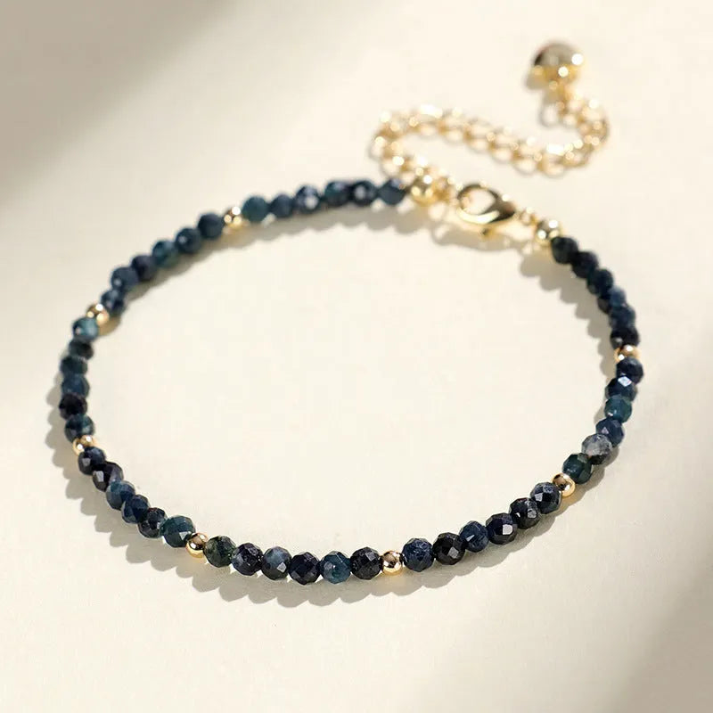 Close-up of a women's blue tourmaline beaded bracelet with 3mm gemstone beads and spacer details.