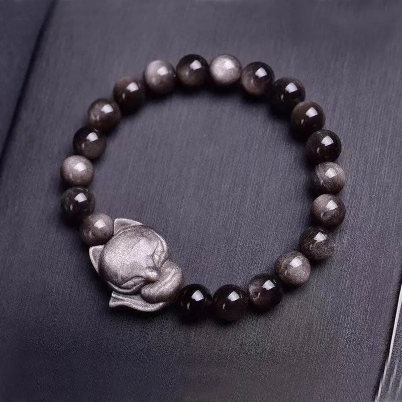 Close-up of a women's adjustable bracelet with a dark obsidian fox bead and sliding knot.