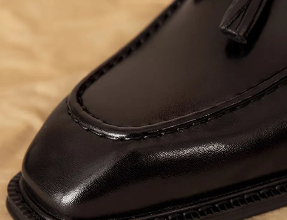 Men's black and brown genuine leather slip-on loafers with a polished finish and rubber sole.