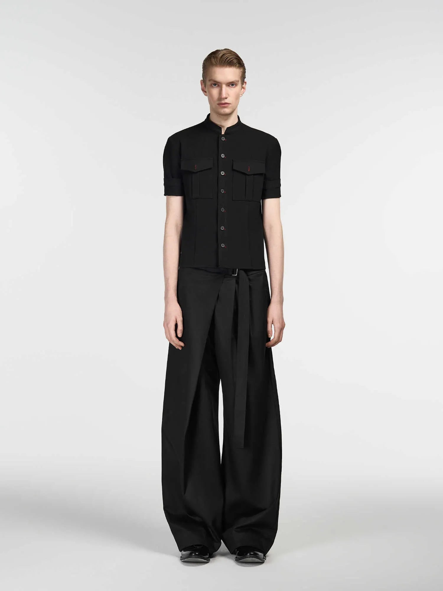Black straight-leg trousers with a single pleat front and an adjustable waistband, laid flat.