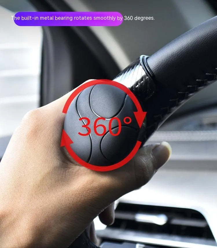 Black silicone steering wheel assist ball with metal bearing mounted on car steering wheel
