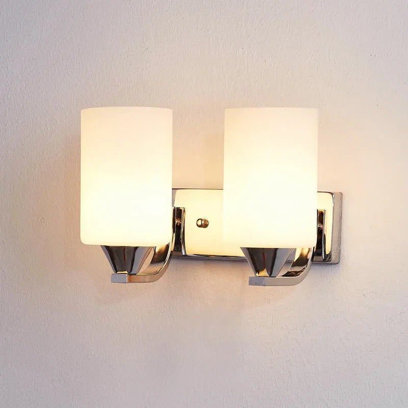Minimalist chrome-finished glass wall lamp with single head configuration on white wall