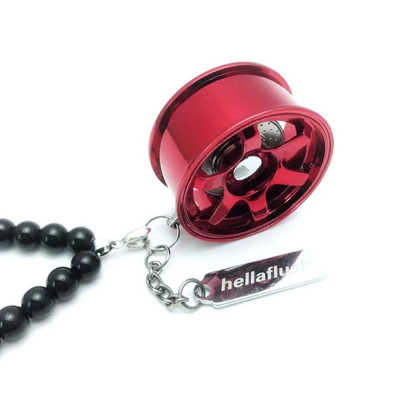 Stainless steel car tyre ornament with crystal glass bead chain hanging from a rearview mirror