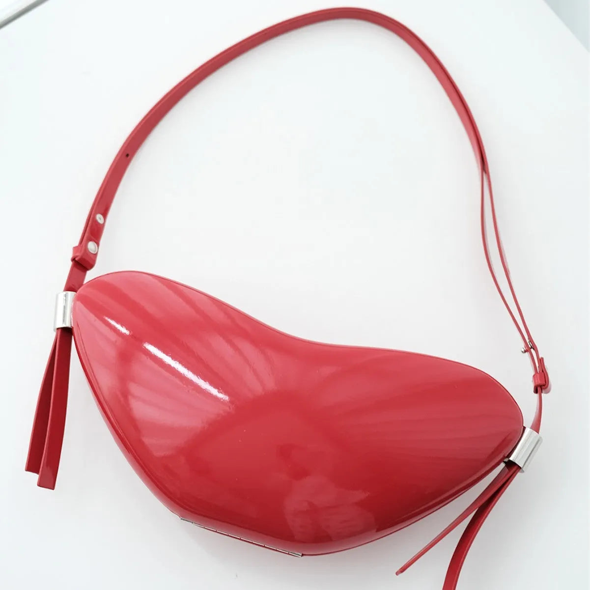 Red heart-shaped crossbody bag in PU material with single shoulder strap and exterior pocket