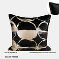 Black and gold abstract pattern decorative velvet cushion on a grey sofa.