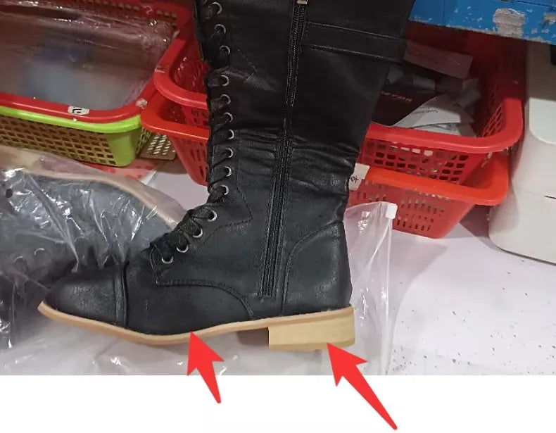 Women's black PU leather knee-high boots with a cross strap detail across the ankle.