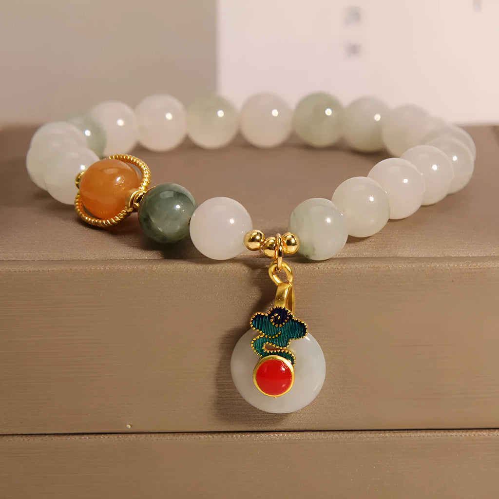 Close-up of a women's ice jade bracelet with a peace jade buckle and pearl decorative elements.