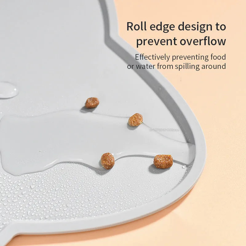 Blue silicone cat head-shaped pet feeding mat on a wooden floor.